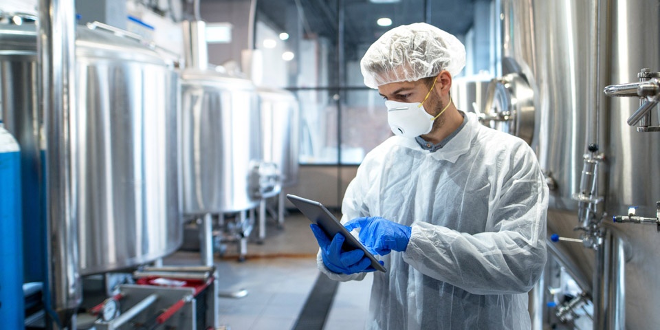 A pharmaceutical technician goes over a check list on a tablet.