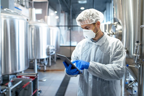 A pharmaceutical technician goes over a check list on a tablet.